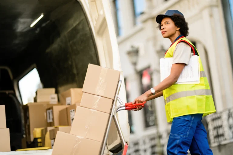 black-female-deliverer-pushing-hands-truck-while-p-2023-11-27-05-33-02-utc